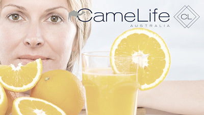 Image of a mature woman and oranges.  Vitamin C in camel milk skincare